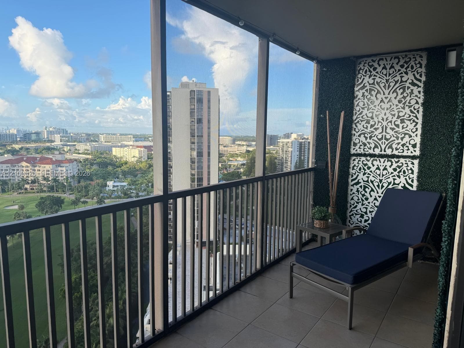 Screened balcony featuring tile flooring, metal railings, and decorative laser-cut wall panels