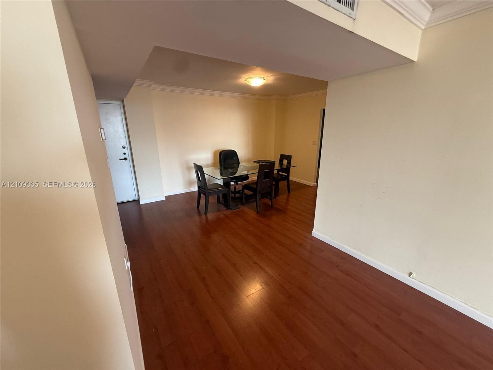 Open interior space featuring wood-finish flooring and crown molding