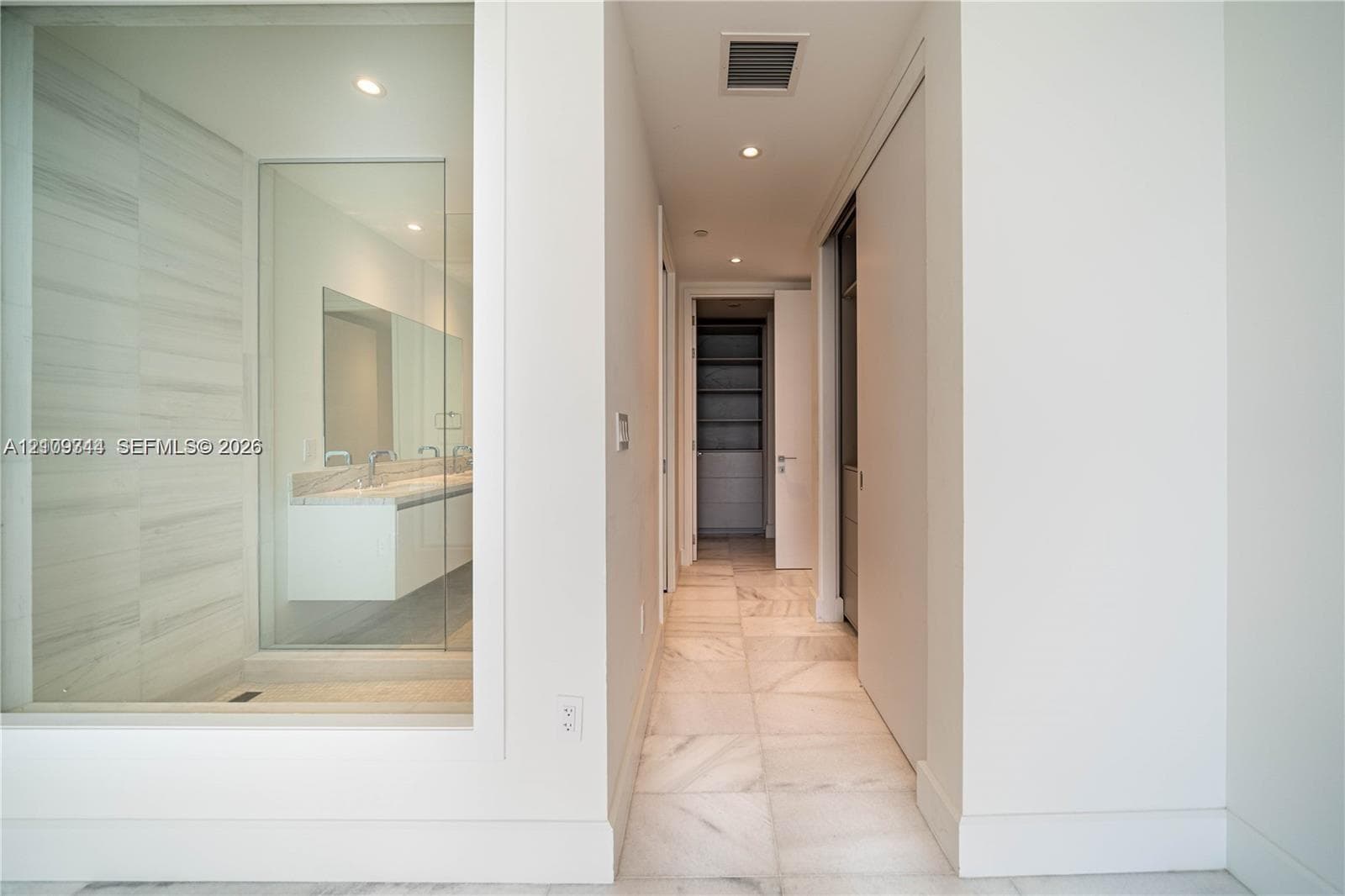 Large-format tile flooring, glass-enclosed shower with horizontal tile wall detailing, wall-mounted floating vanity, and recessed lighting