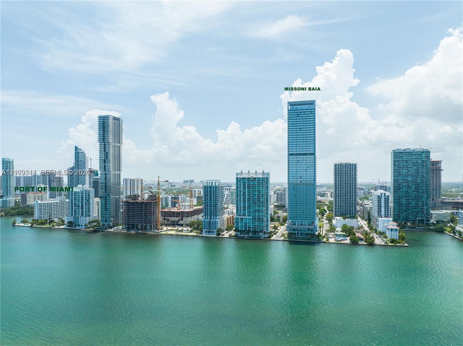 Aerial perspective of coastal high-rise development featuring expansive glass-facade towers, direct waterfront positioning, and proximity to maritime infrastructure