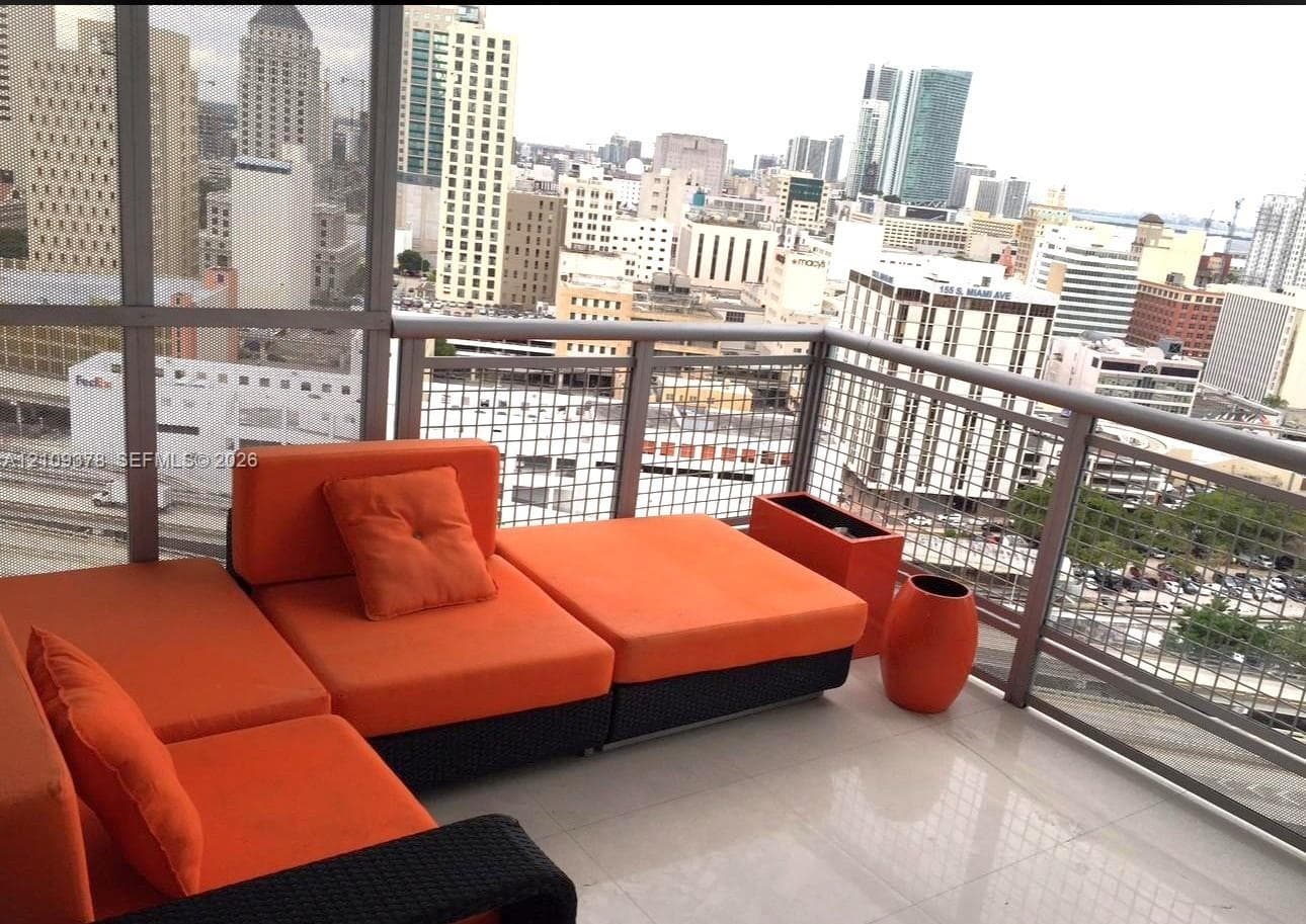 Covered balcony featuring large-format tile flooring and metal railing with wire mesh infill panels