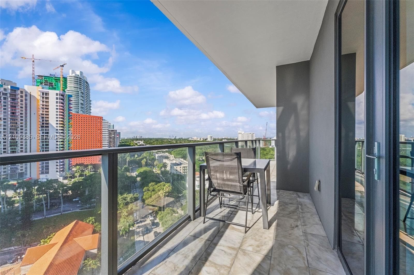 Private balcony featuring stone-finish flooring and a full-height glass railing