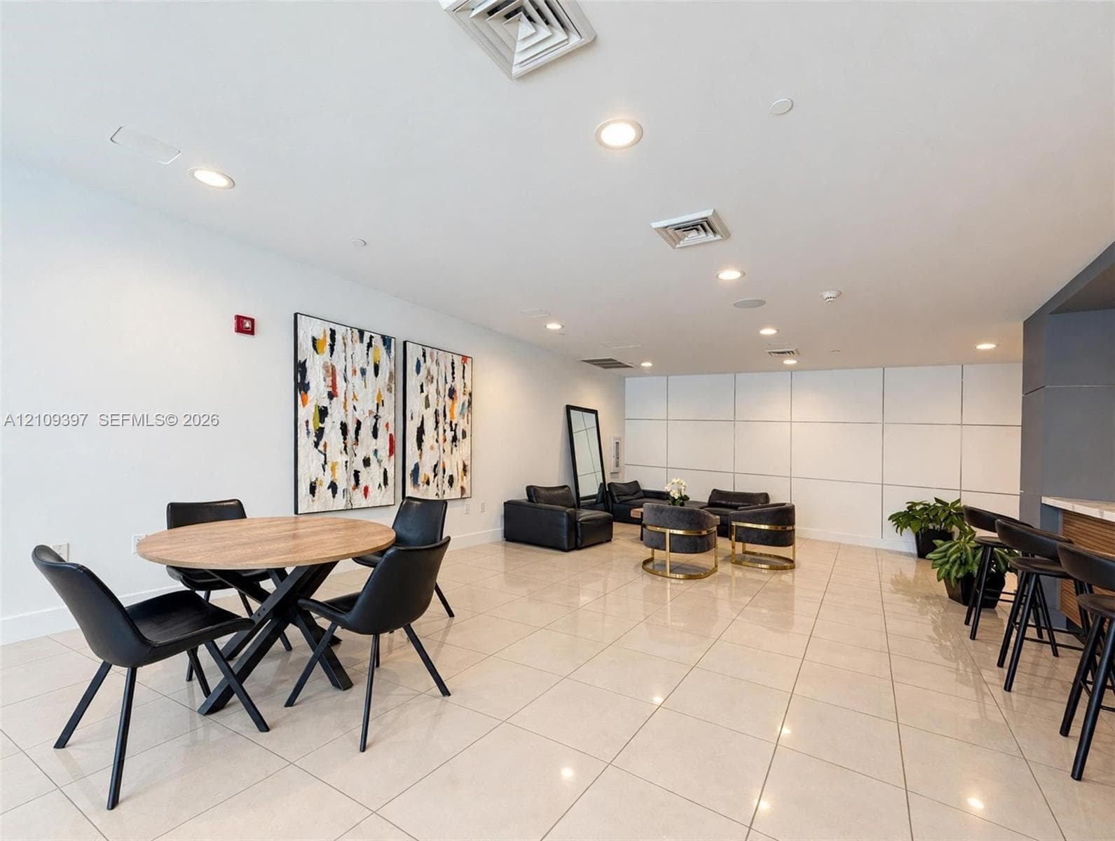 Neutral-toned tile flooring, recessed ceiling lighting, and large-scale wall paneling