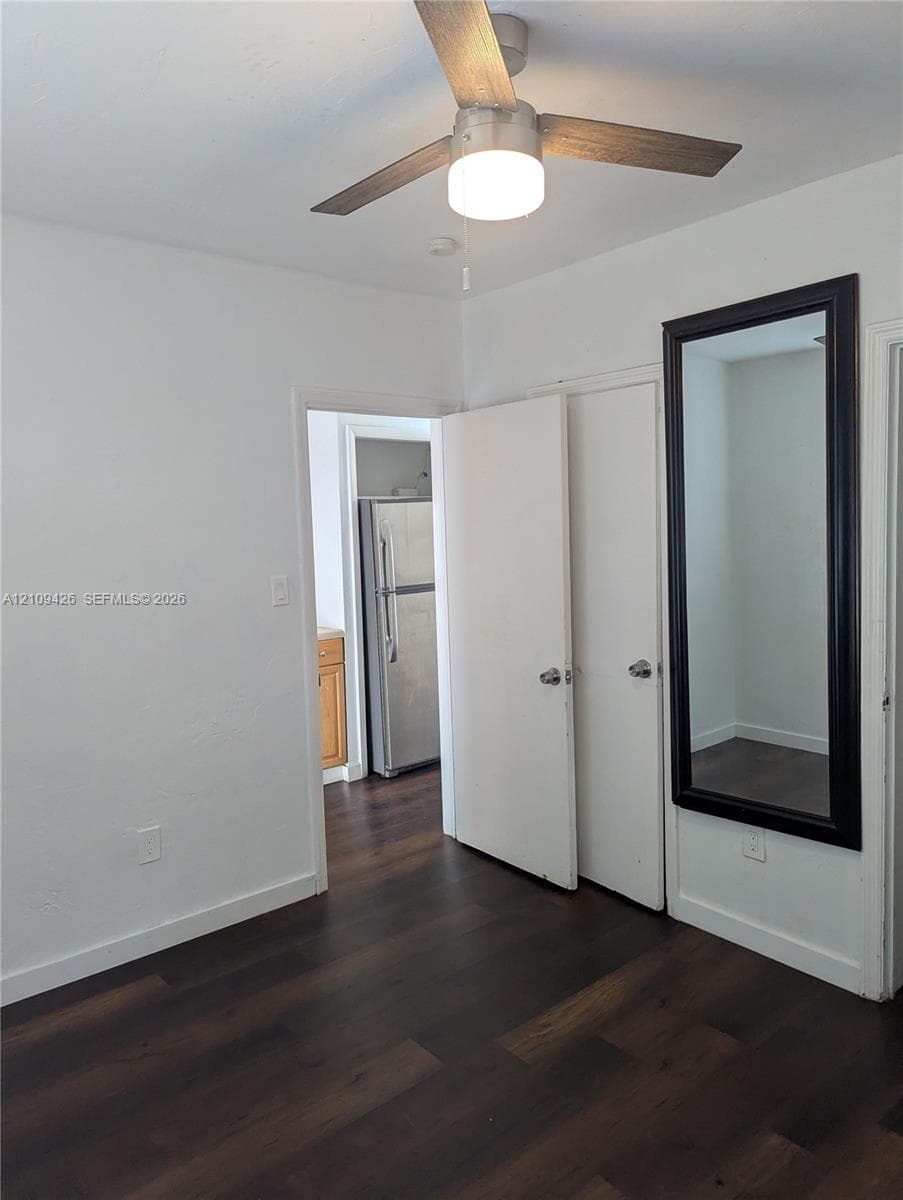Wood-finish flooring, ceiling fan with integrated lighting, and dual hinged doors