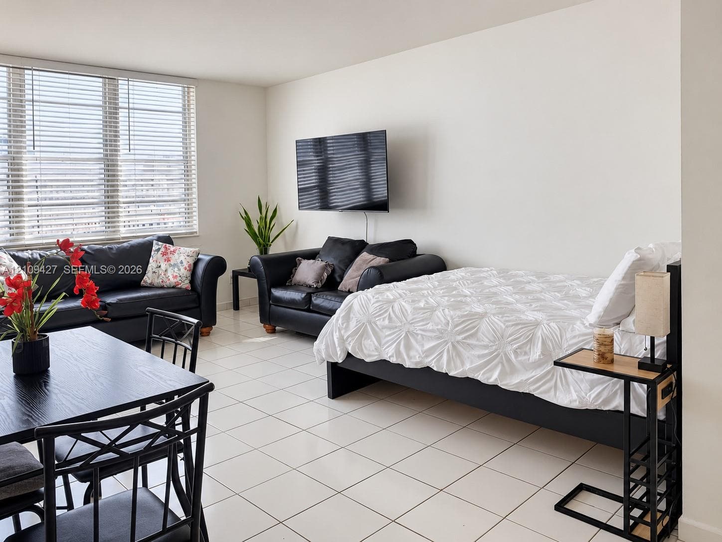 Neutral-toned interior featuring large-format ceramic tile flooring and floor-to-ceiling windows with integrated horizontal blinds