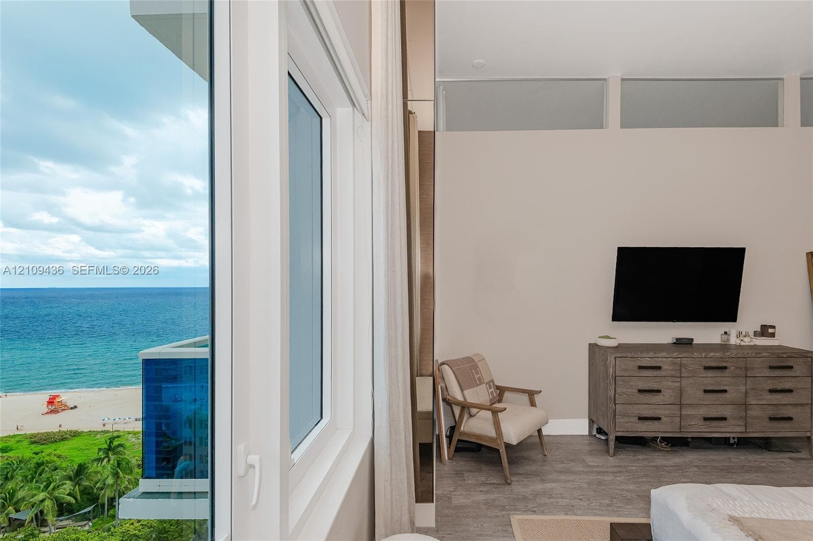 Floor-to-ceiling glass windows, transom windows, neutral wall palette, and wood-finish flooring