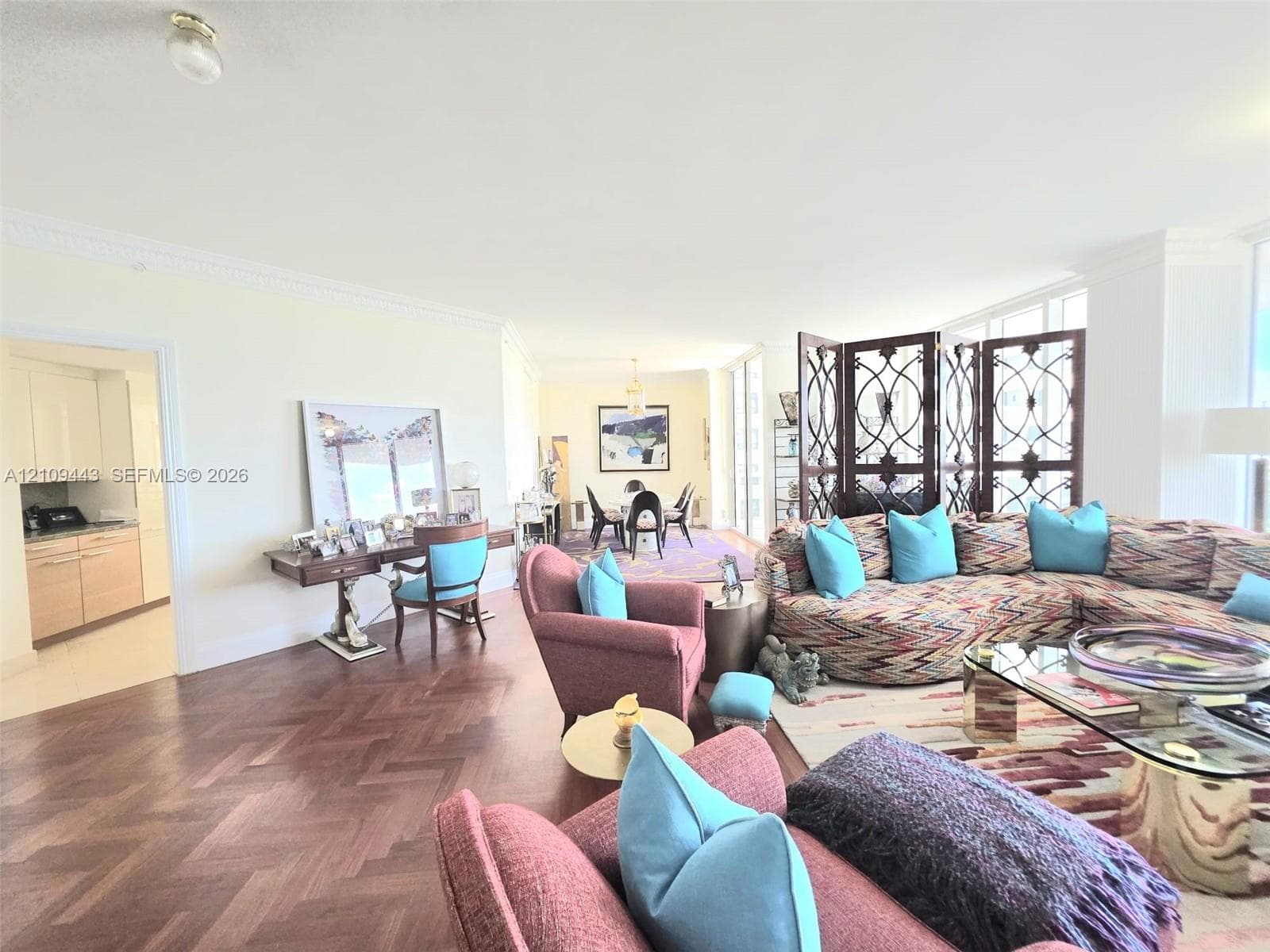 Herringbone-patterned wood-finish flooring, crown molding, floor-to-ceiling windows, and recessed ceiling lighting