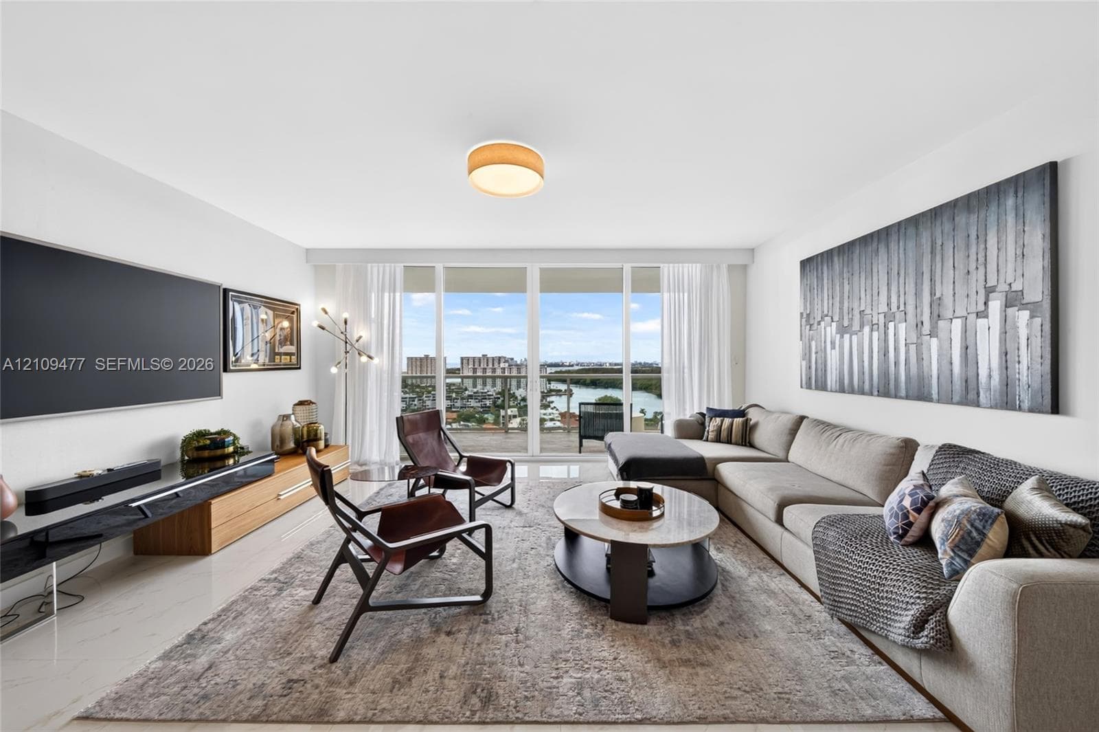 Floor-to-ceiling windows, wood-finish flooring, accent wall, and flush-mount ceiling lighting