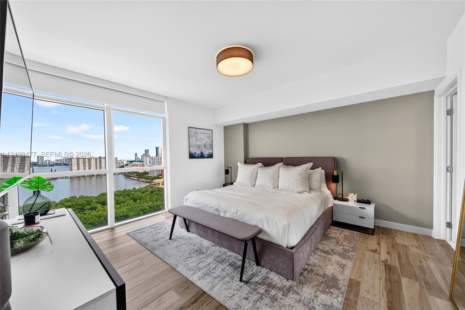 Open-concept space featuring floor-to-ceiling windows, white polished tile flooring, contemporary linear LED pendant lighting, and a glass-railed balcony