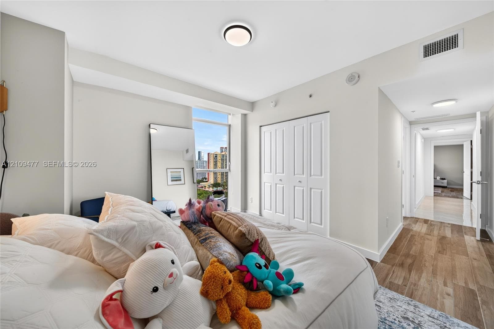 Open-concept living space featuring high-gloss tile flooring, recessed lighting, neutral wall finishes, and integrated cabinetry