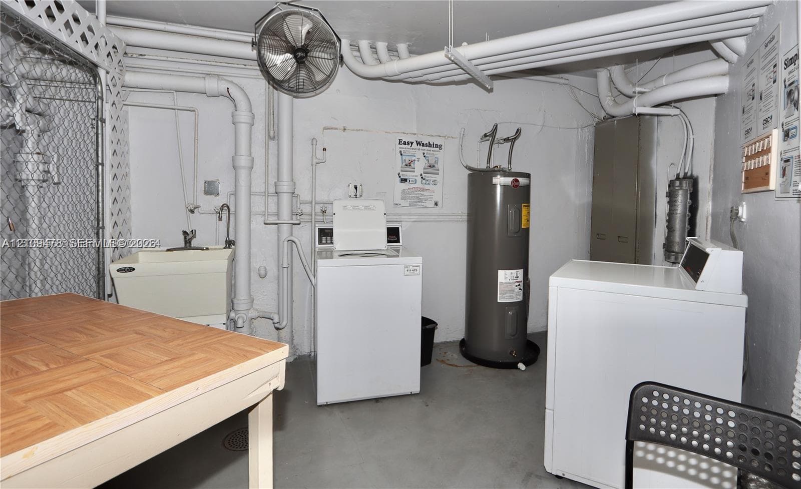 Utility area featuring a top-load washer, a vertical water heater, a basin sink with a wall-mounted faucet, and an overhead ventilation fan