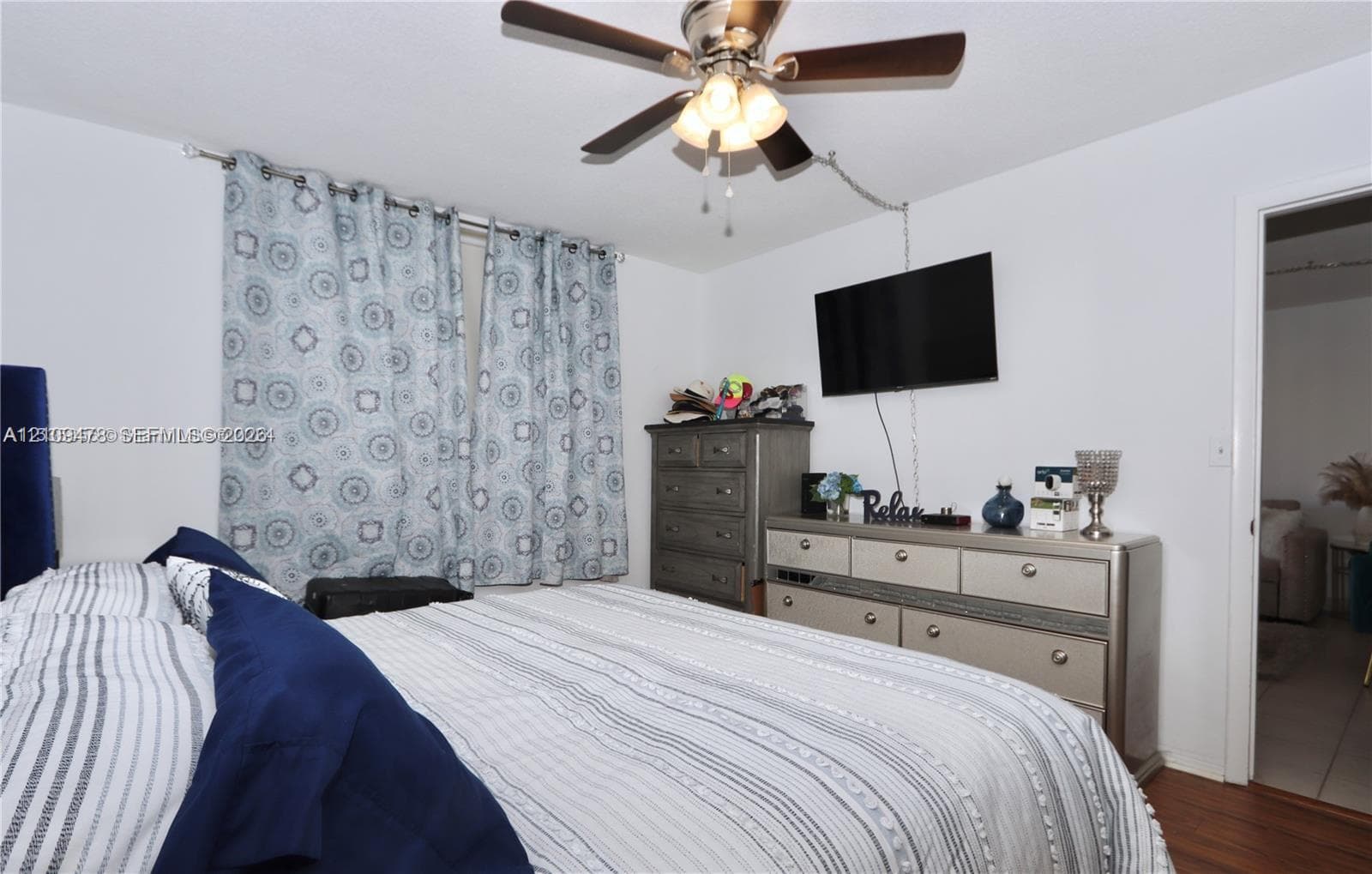 Room featuring a ceiling fan with integrated light fixture and wood-finish flooring