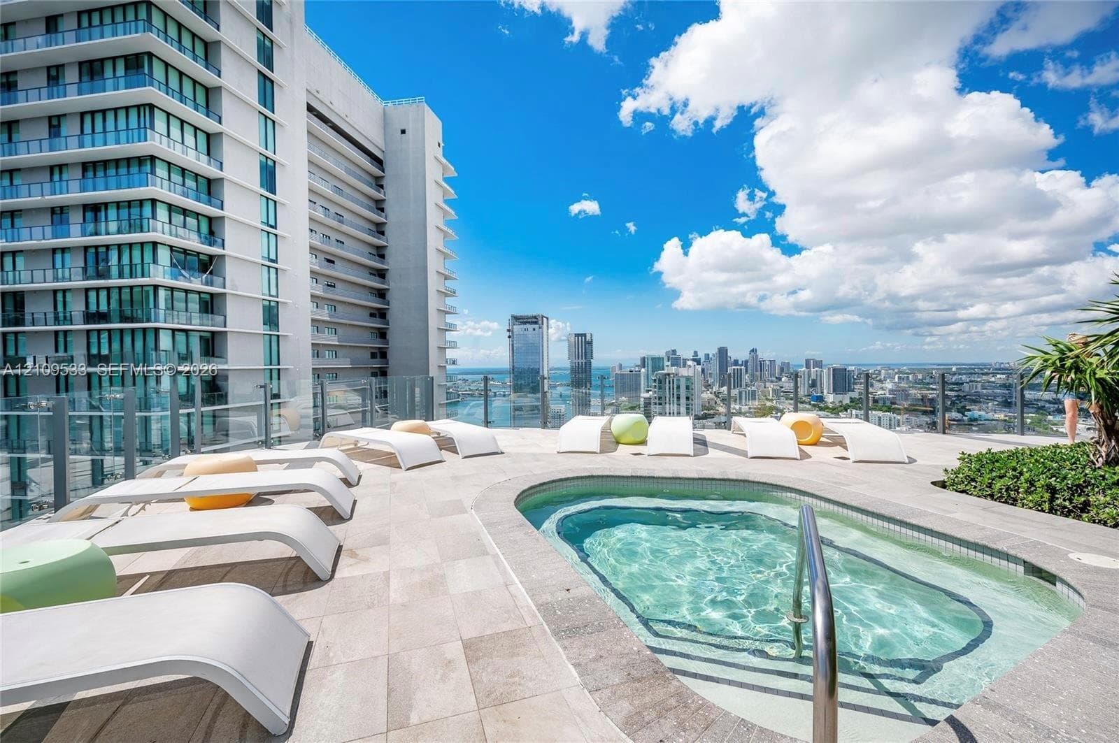 Rooftop terrace featuring an in-ground pool, stone-tile decking, and a glass-panel perimeter railing