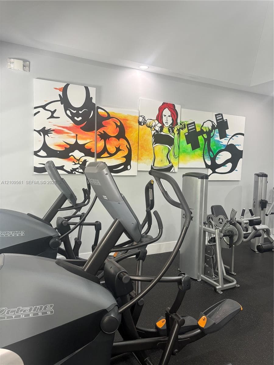 Dedicated fitness room featuring rubberized flooring and recessed lighting