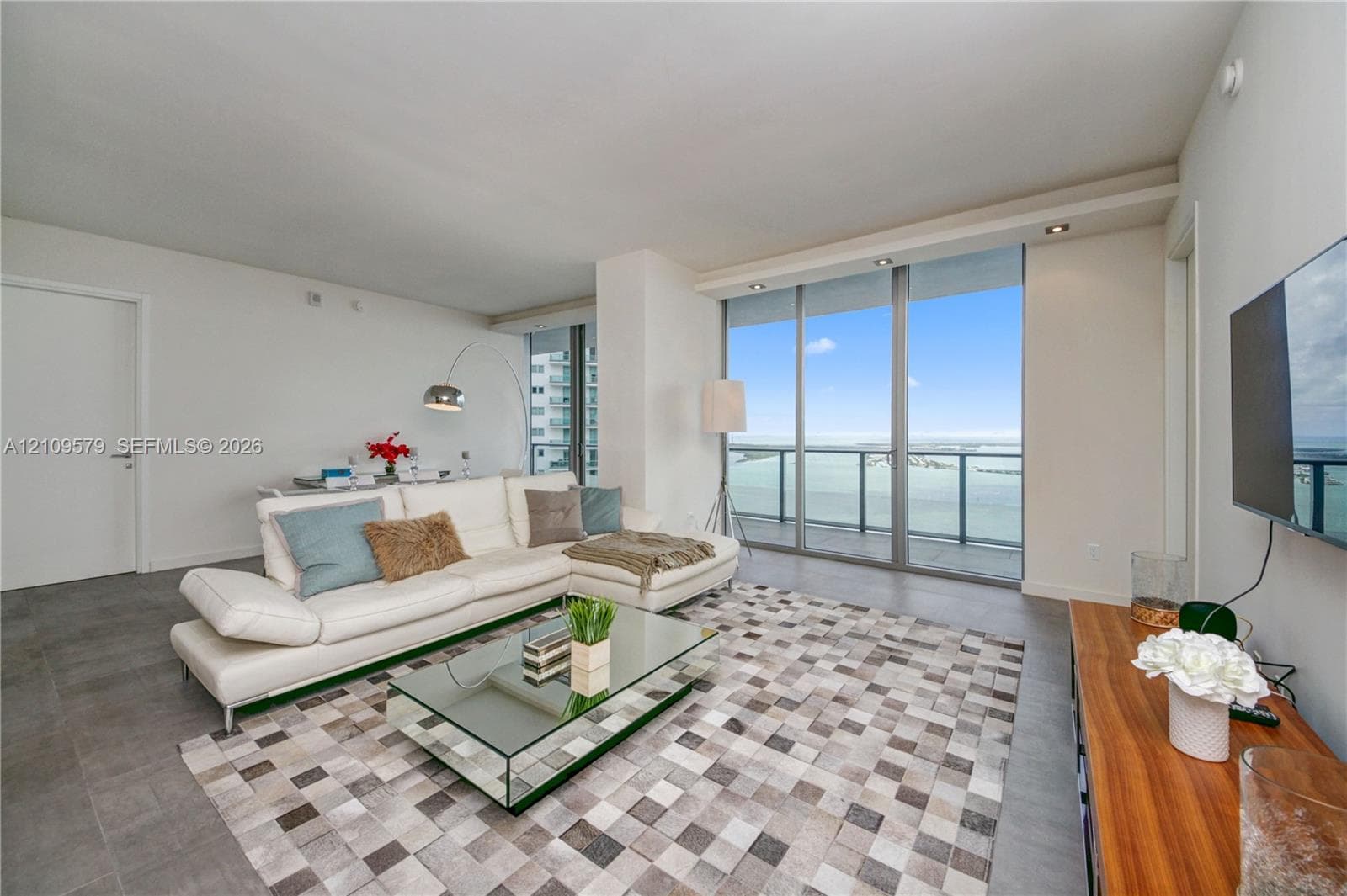 Floor-to-ceiling glass windows, recessed ceiling lighting, and large-format tile flooring