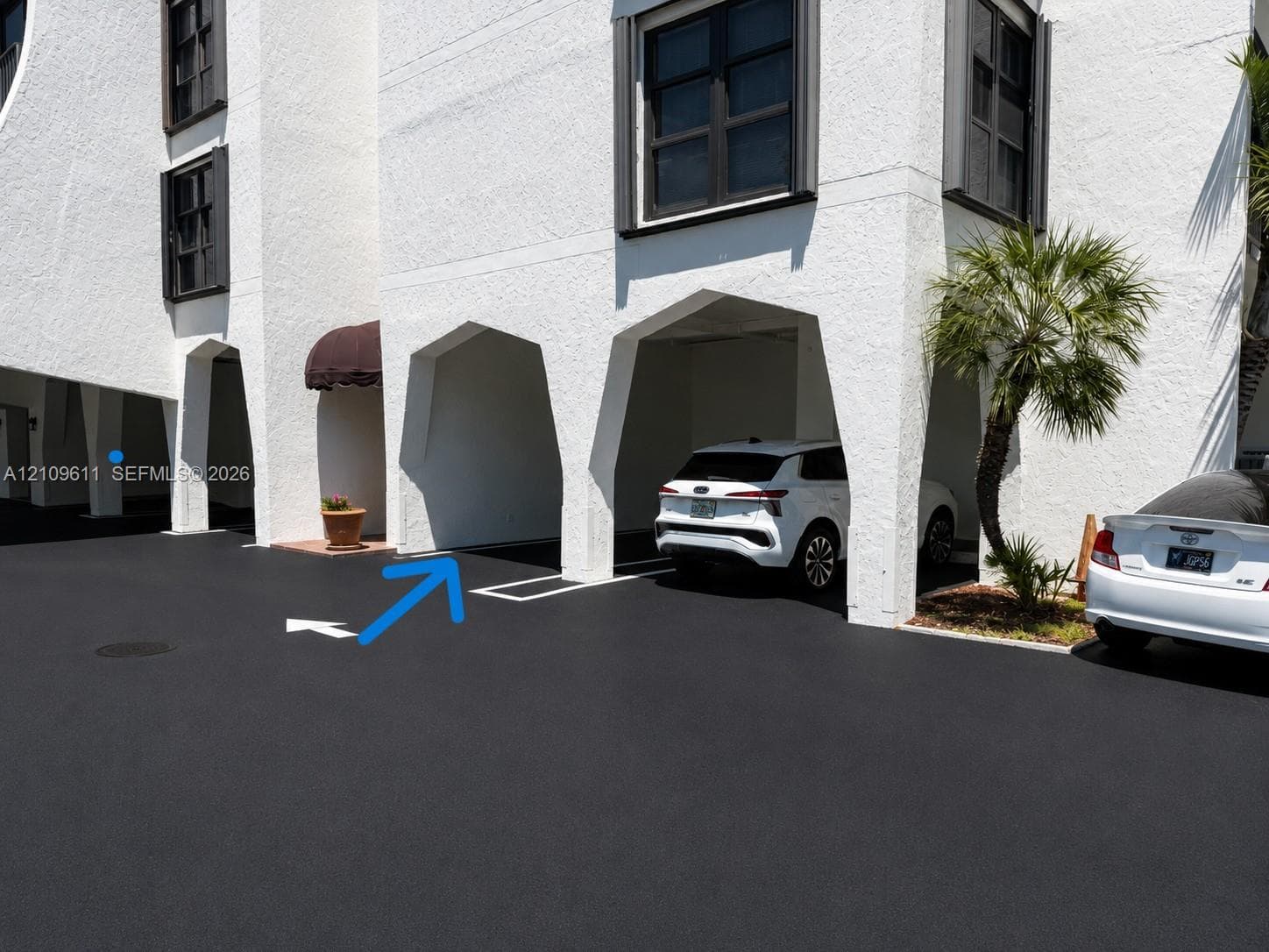 Stucco exterior featuring architectural arched supports and covered ground-level parking
