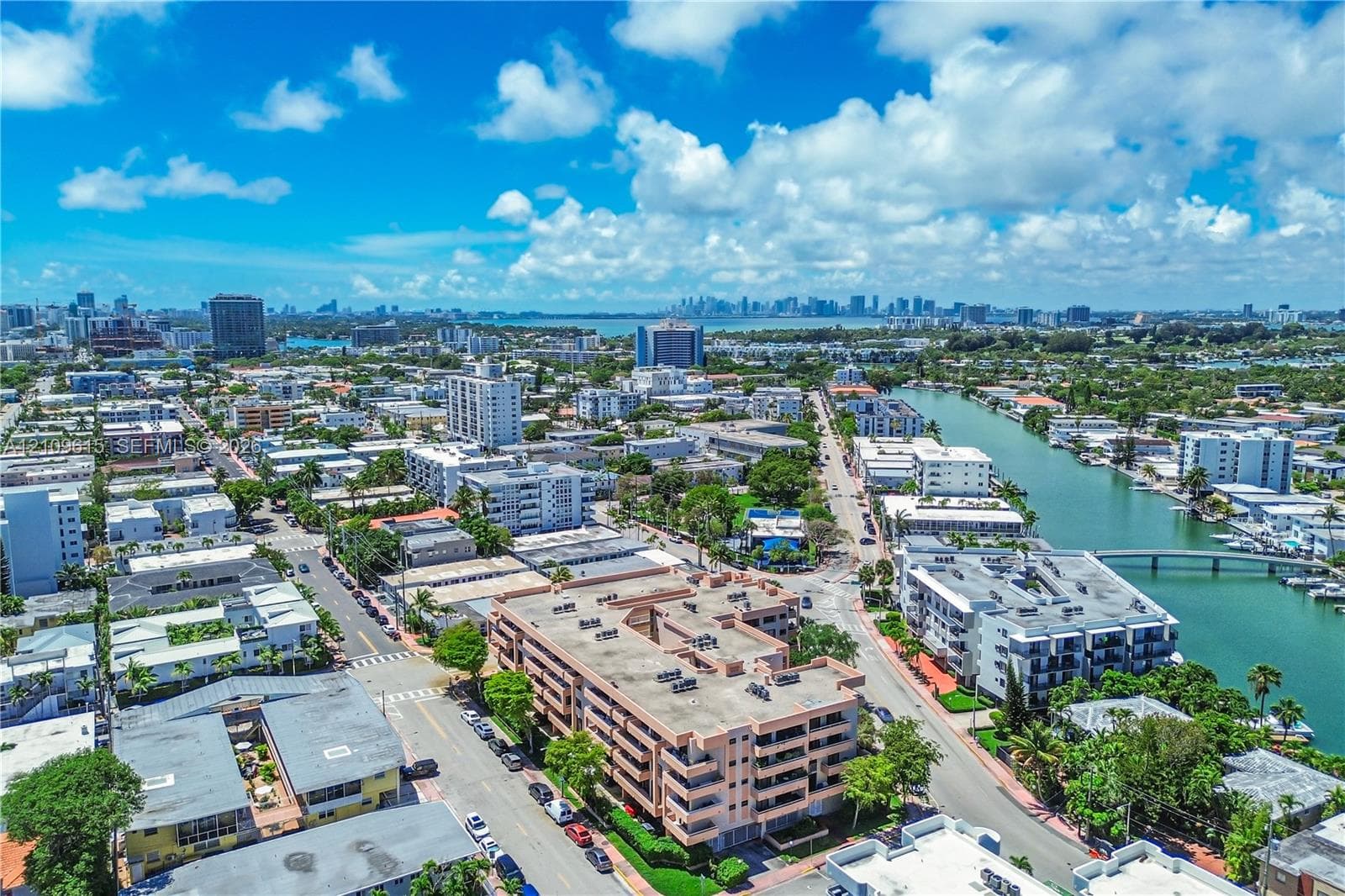 Aerial perspective featuring a multi-story residential building located near a waterfront canal