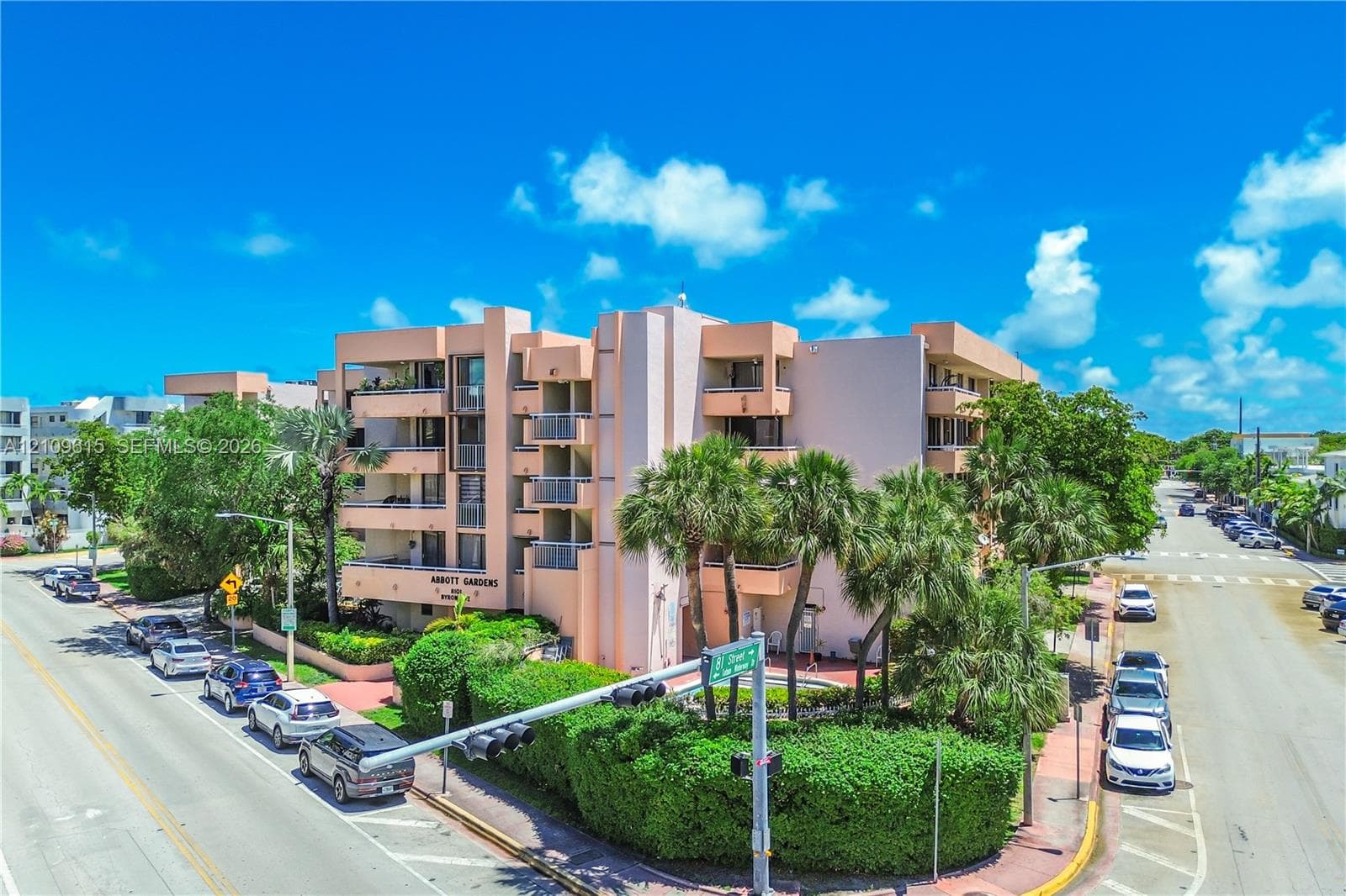 Multi-story residential complex featuring concrete facade, private balconies, and perimeter landscaping