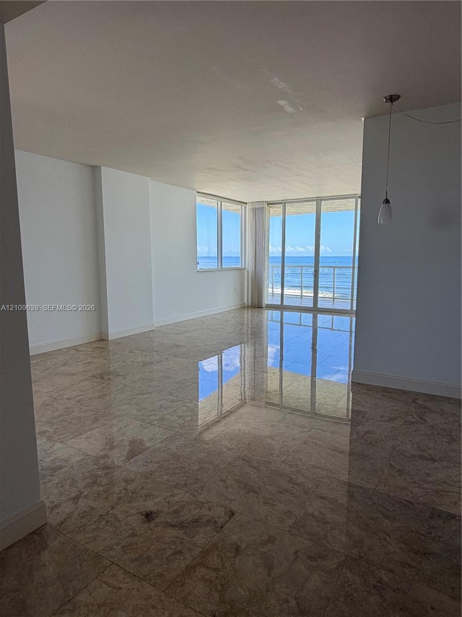 Polished stone flooring, floor-to-ceiling windows, sliding glass door, and balcony