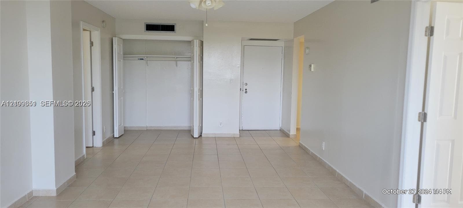 Neutral-toned interior featuring ceramic tile flooring, a closet with bi-fold doors, and a ceiling-mounted light fixture