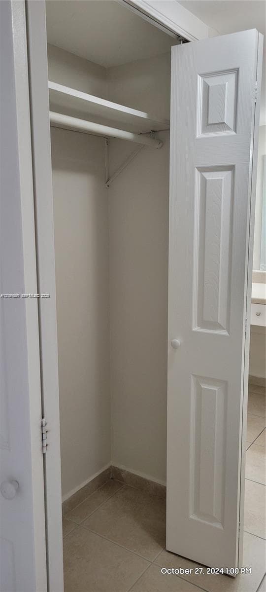 Closet featuring a three-panel door and an integrated upper shelving rod