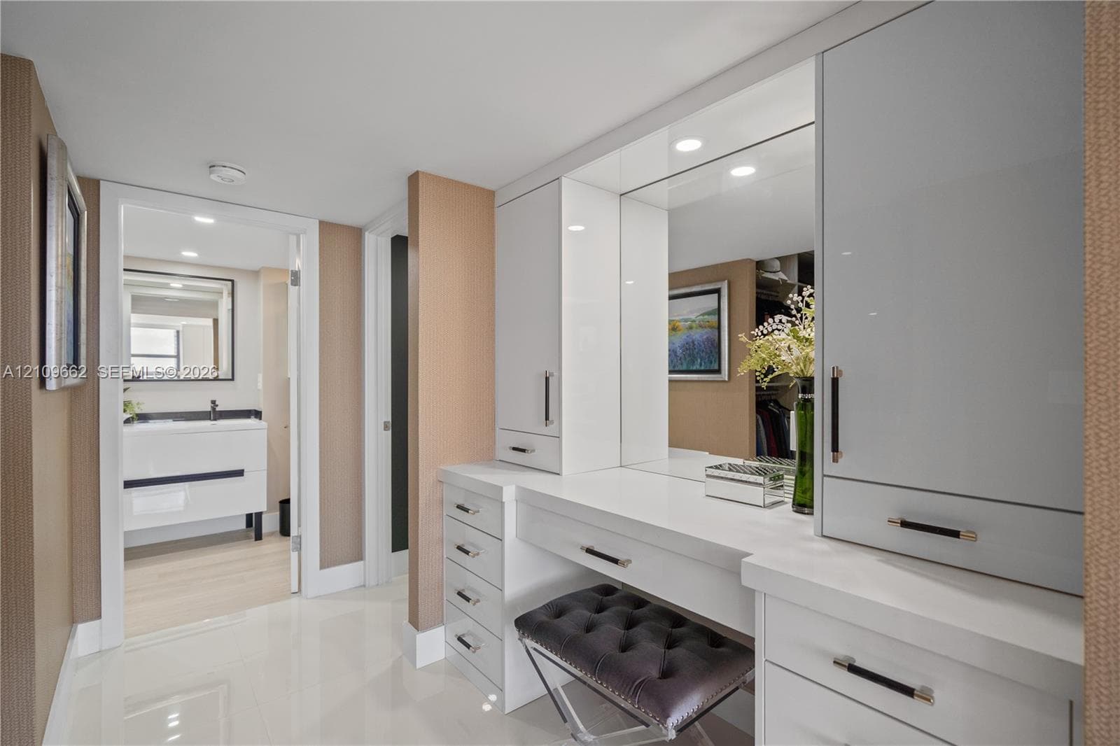 Spacious interior featuring high-gloss flooring, large picture window with built-in cabinetry, and full-height wardrobe storage