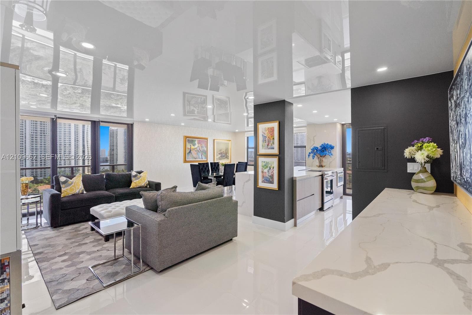 High-gloss reflective ceiling, stone countertop with waterfall edge, recessed lighting, floor-to-ceiling windows, and polished porcelain flooring