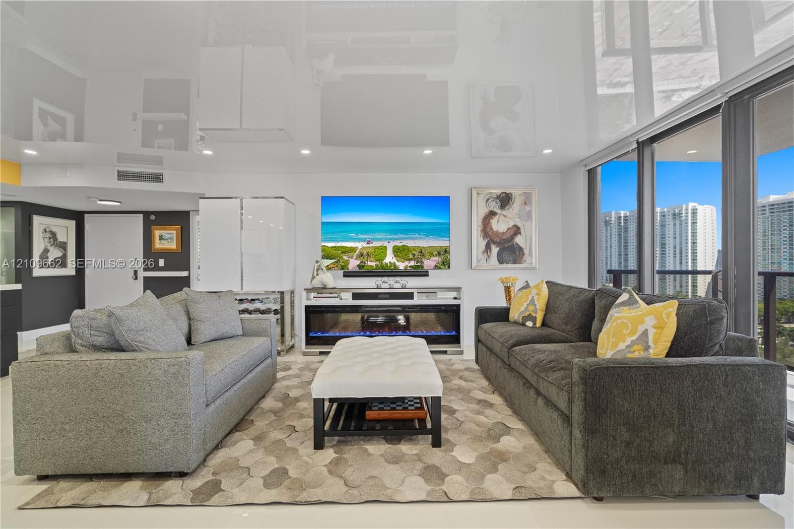 High-gloss reflective ceiling, built-in electric fireplace, floor-to-ceiling glass windows, and light-toned tile flooring