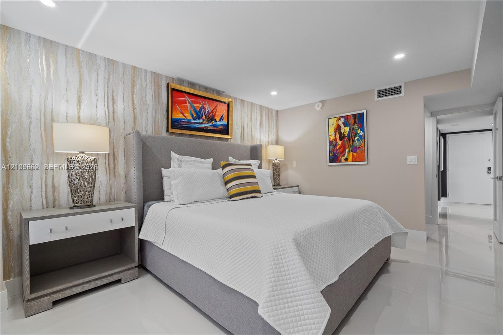 Bedroom featuring a textured metallic accent wall, high-gloss tile flooring, and recessed ceiling lighting