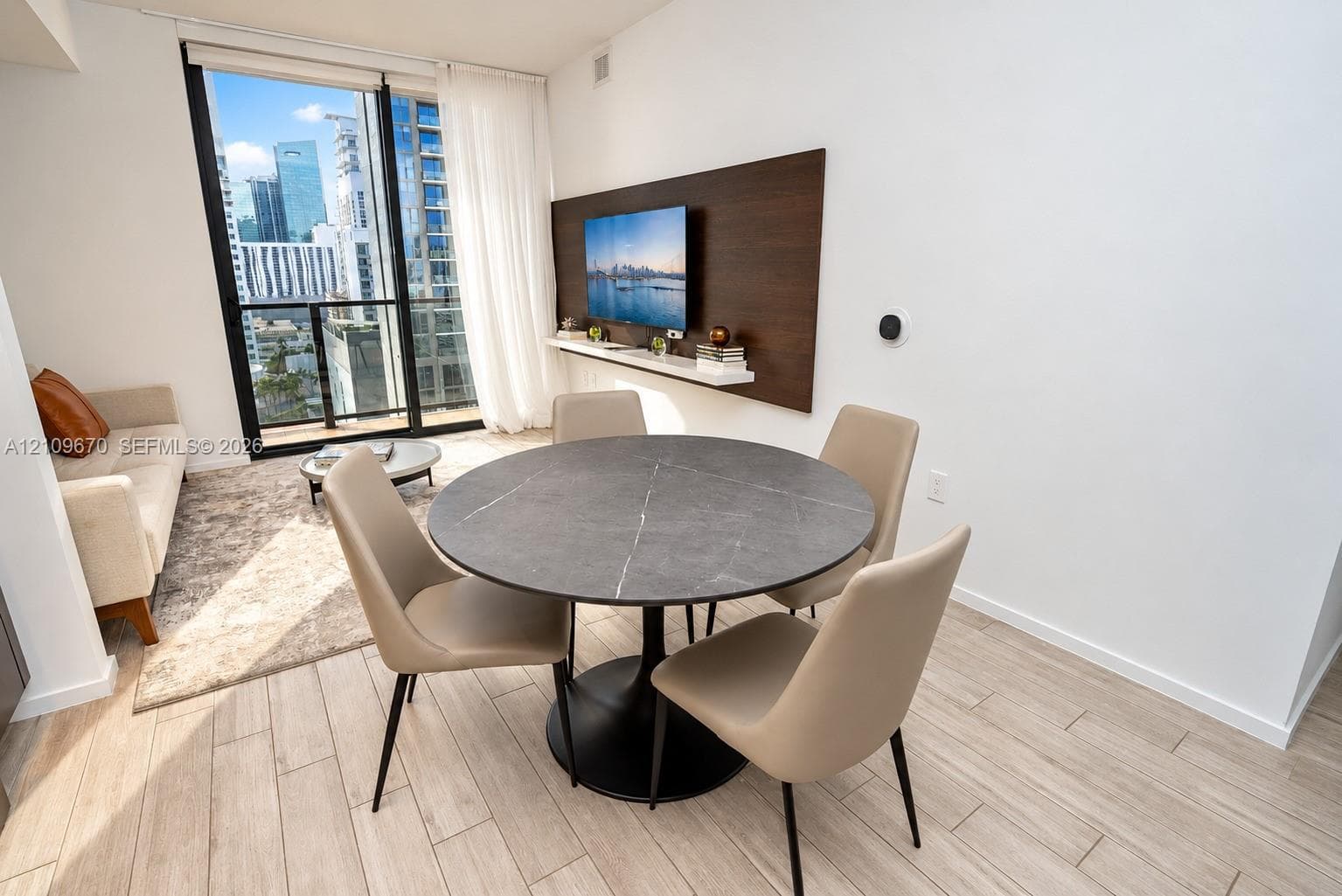 Floor-to-ceiling glass door, wood-finish tile flooring, and integrated wall-mounted media console