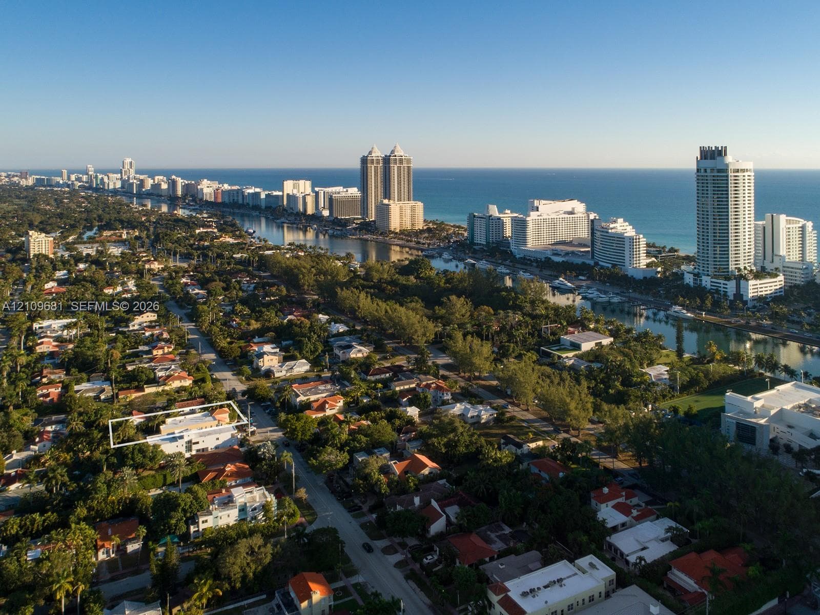 Aerial perspective of coastal residential property featuring a flat roofline, multi-level exterior architecture, and mature perimeter landscaping