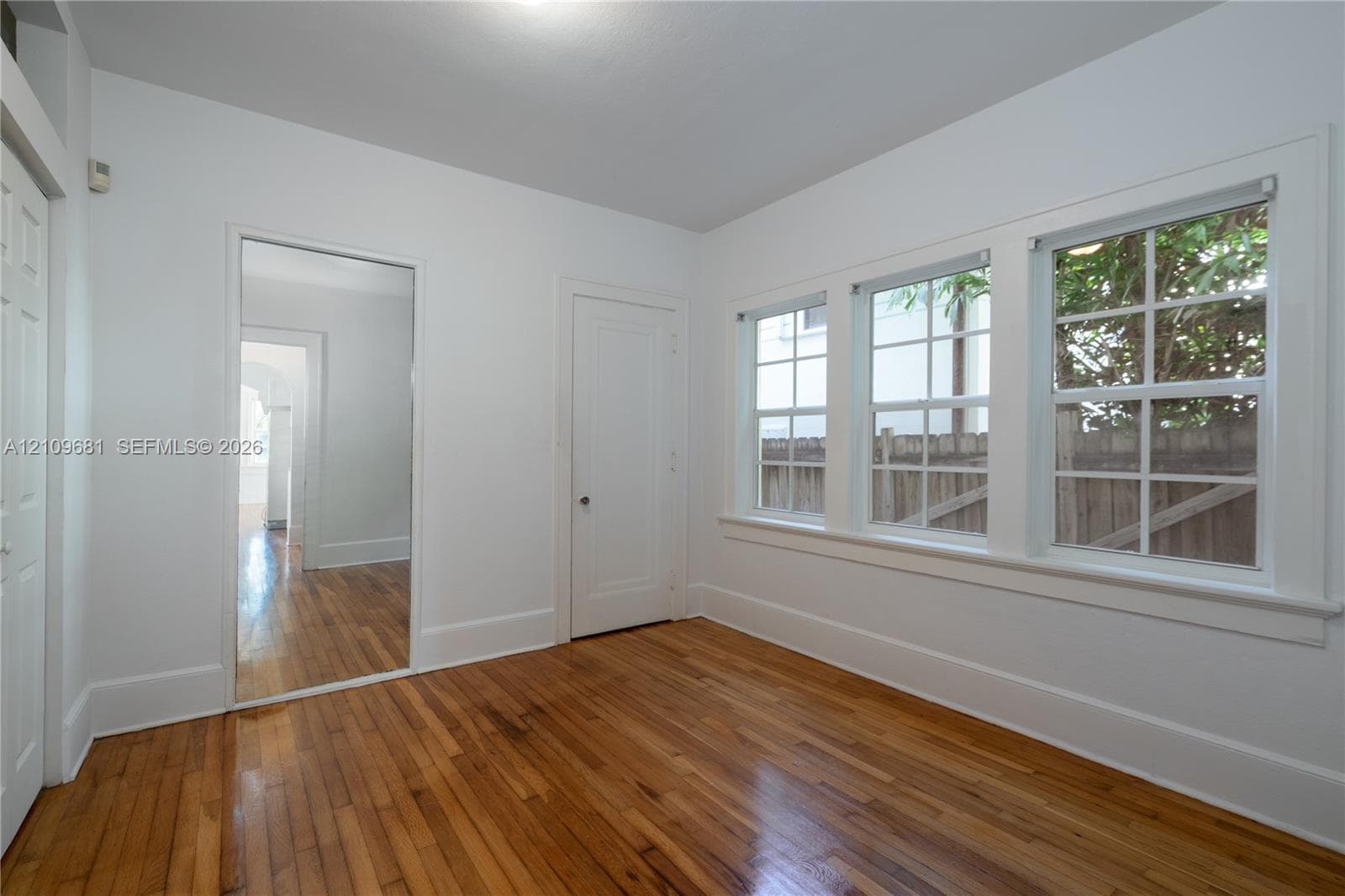 Interior space featuring wood flooring, multi-pane windows, and solid-core doors