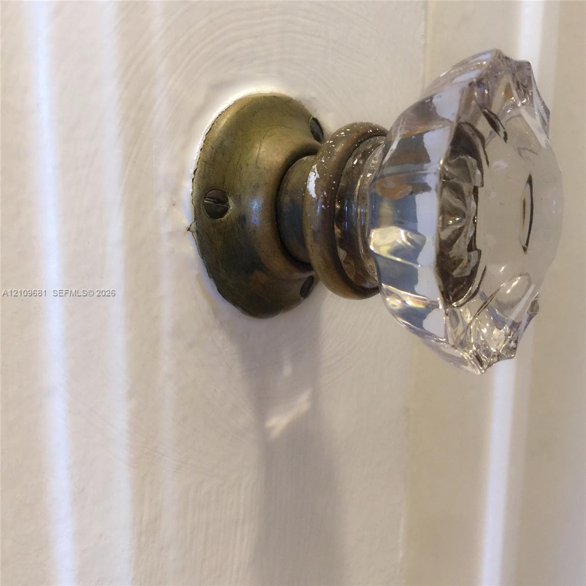 Facet-cut crystal door knob featuring a circular brass backplate