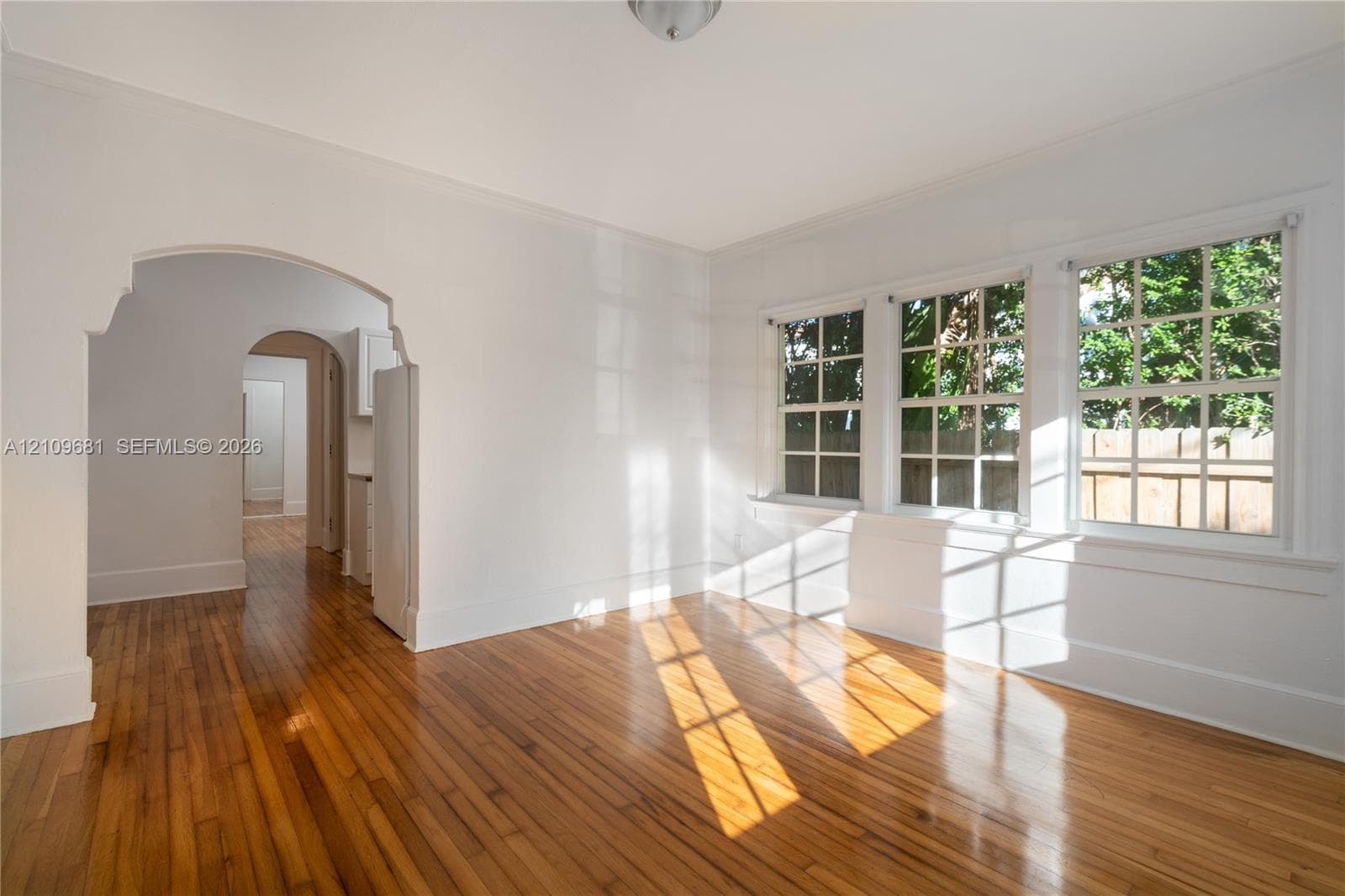 Wood-finish flooring, multi-pane windows, and architectural arched doorways