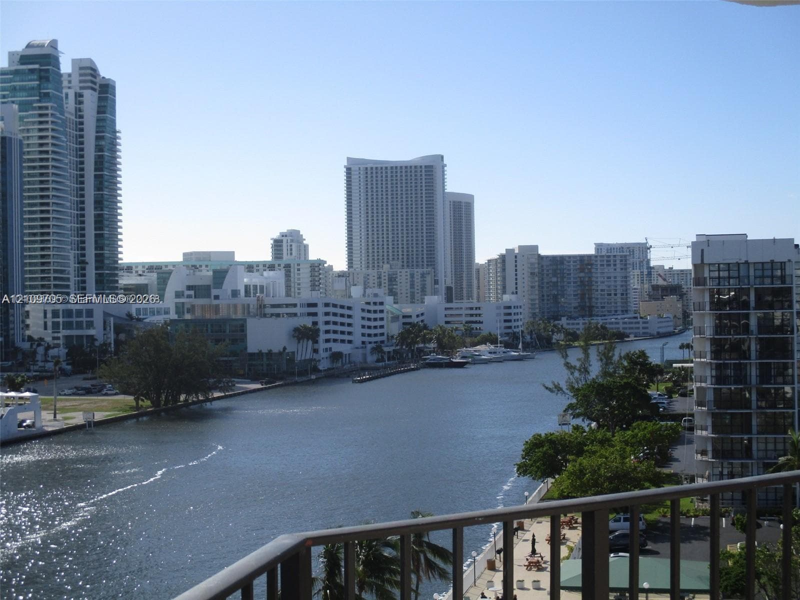 Elevated balcony with metal railing overlooking the waterway and city skyline