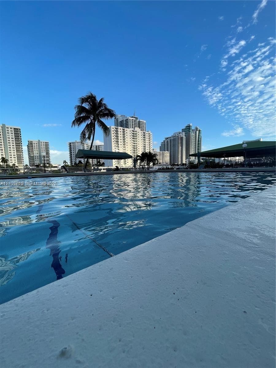 Swimming pool with a concrete deck and a cityscape background