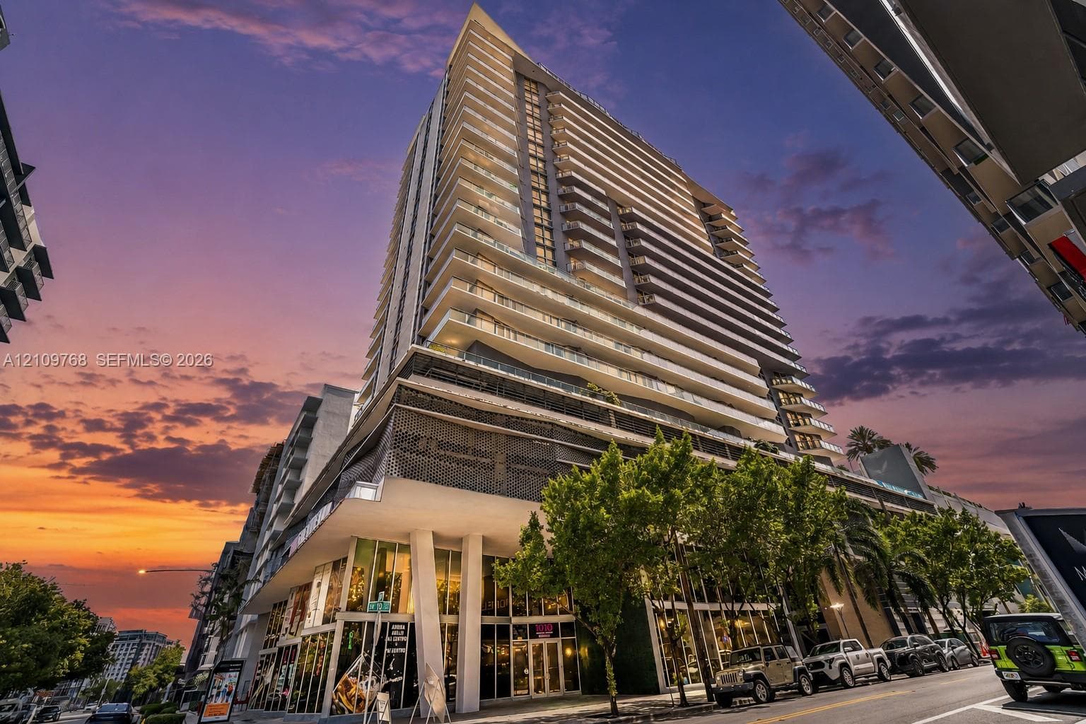 High-rise architectural exterior featuring glass-railed private balconies, floor-to-ceiling windows, and decorative geometric façade screening