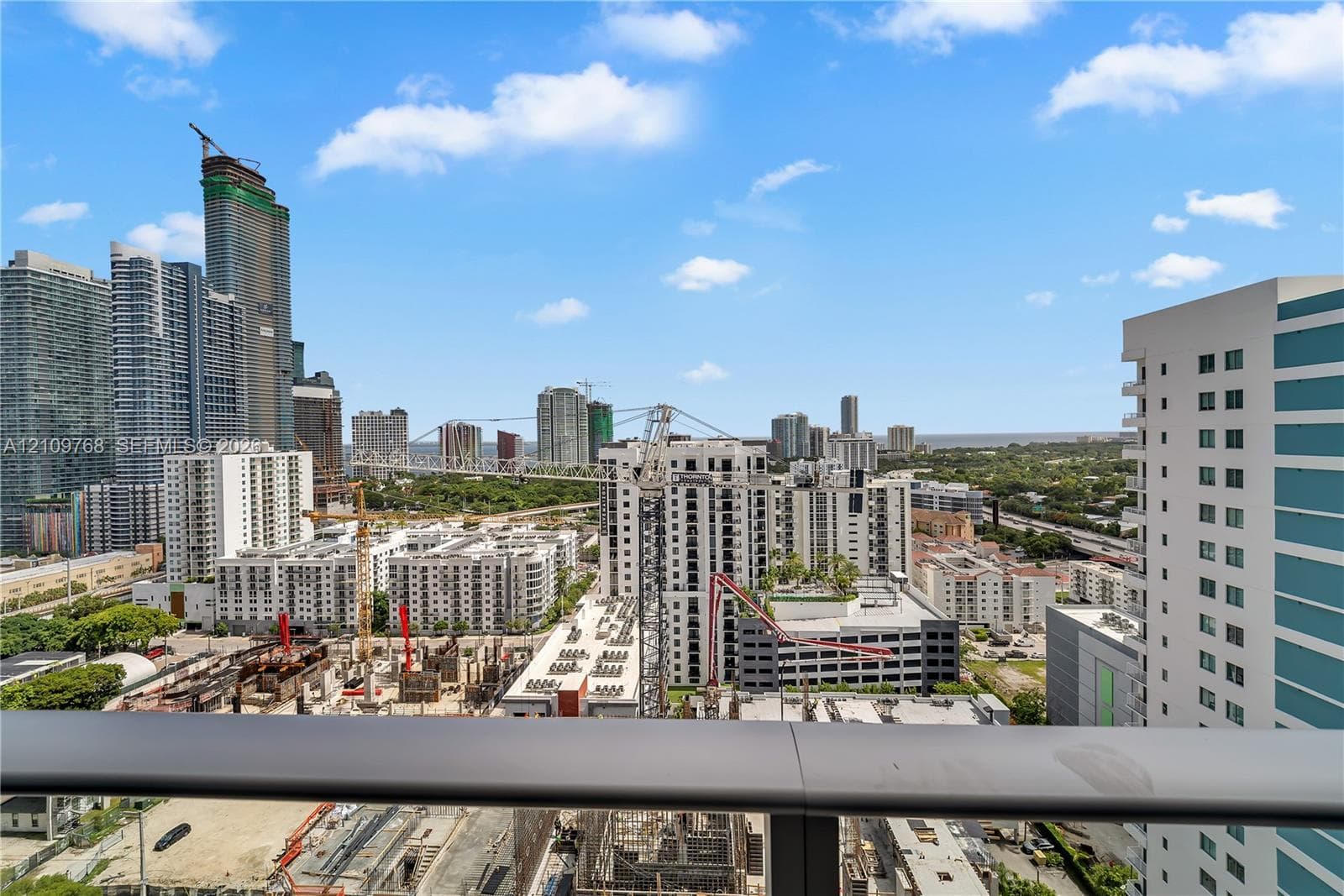 Elevated balcony featuring a matte-finish metal railing with expansive exterior perspectives of the surrounding urban skyline