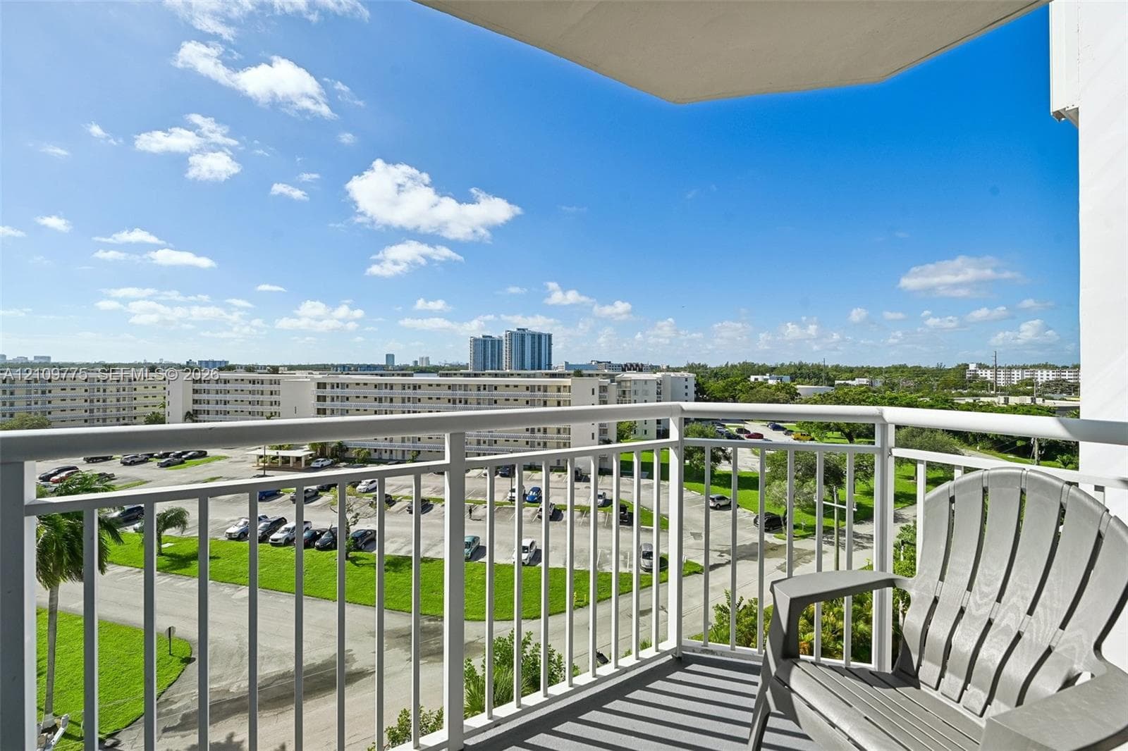 Private balcony with white metal railings and concrete flooring