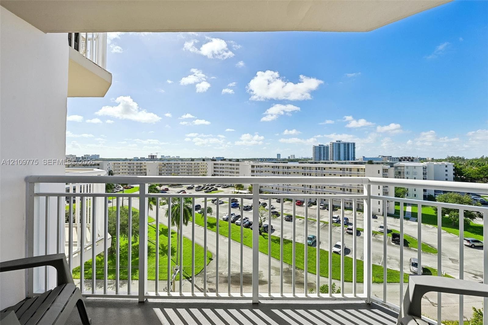 Private balcony featuring a white metal railing and concrete flooring