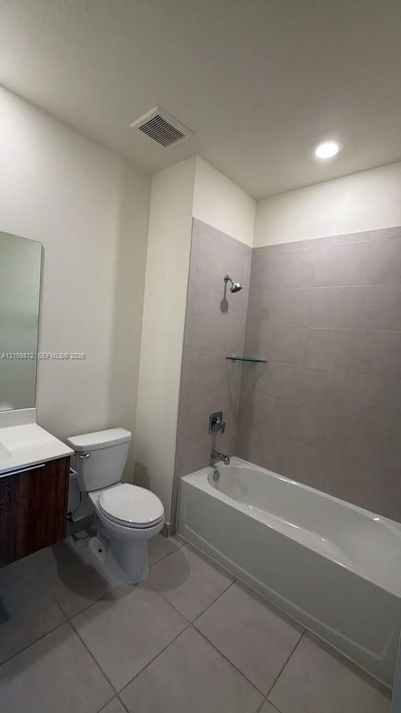 Bathroom featuring a wood-finish vanity with a white countertop, a white soaking tub, large-format tile shower surround, and ceramic tile flooring