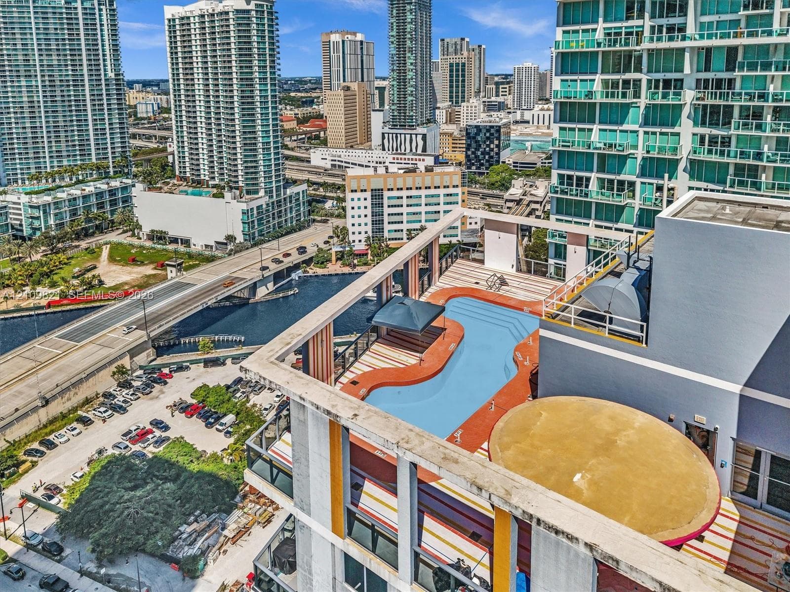 Rooftop pool featuring a tiered deck, built-in structural shading, and an urban skyline backdrop