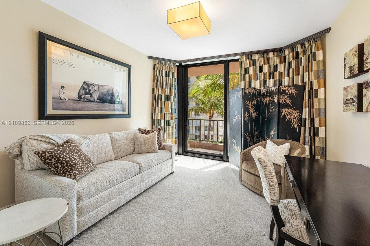 Neutral-toned carpeting, square architectural ceiling lighting, and floor-to-ceiling glass sliding doors providing access to an exterior balcony