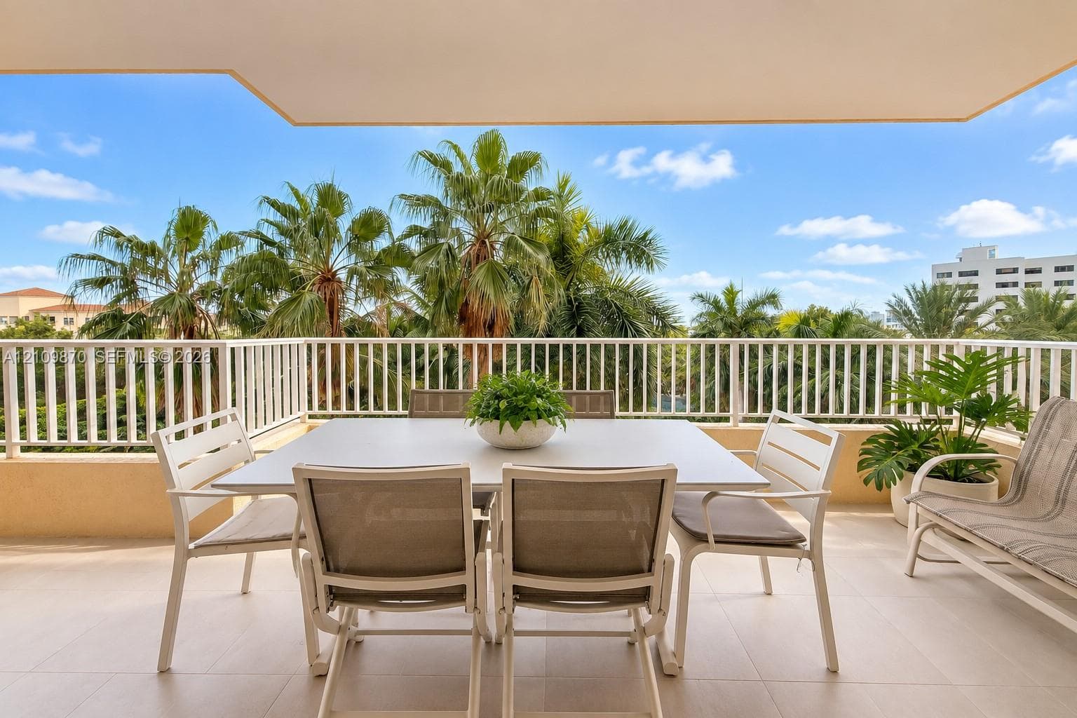 Covered balcony featuring tile flooring and a white railing