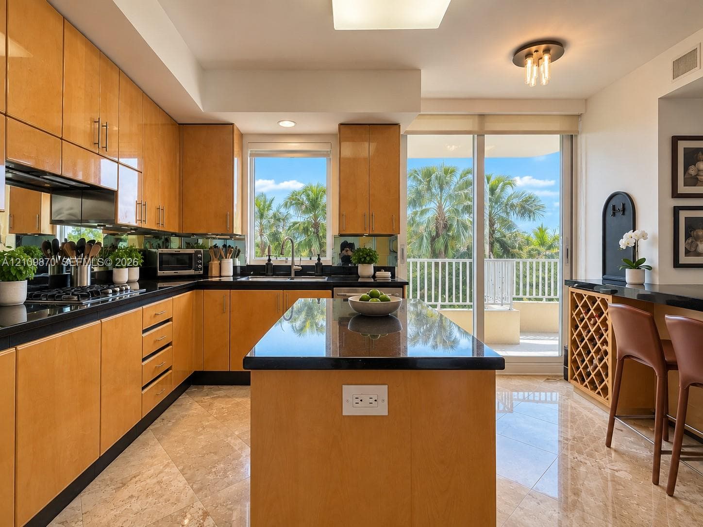 Kitchen featuring flat-panel wood cabinetry, black countertops, central island, stone-finish flooring, and built-in wine storage