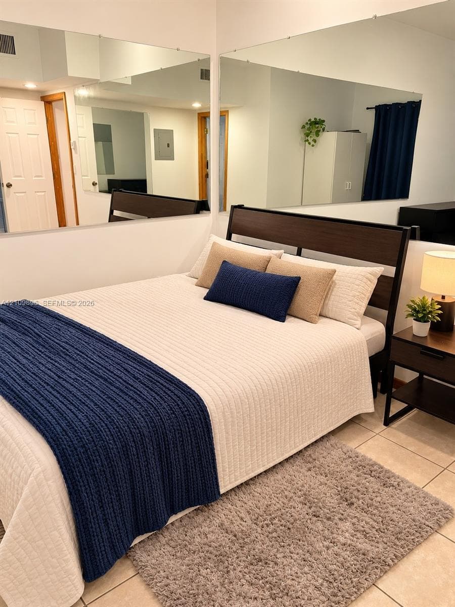Large-format wall mirrors, neutral ceramic tile flooring, and multi-panel interior doors