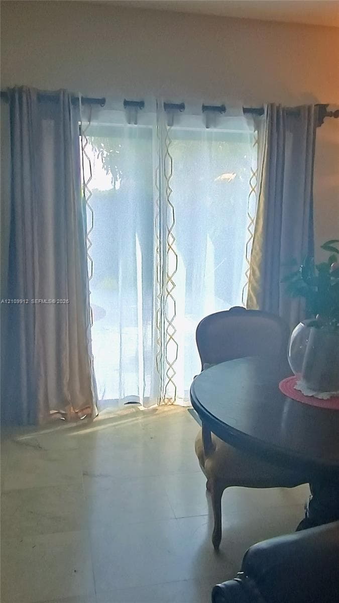 Sliding glass door with neutral stone-finish flooring
