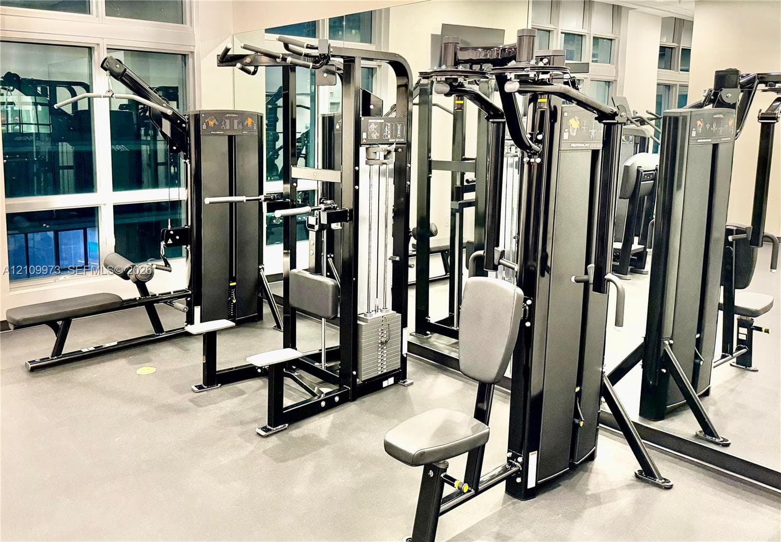 Fitness center featuring large-scale floor-to-ceiling mirrors and expansive multi-pane windows