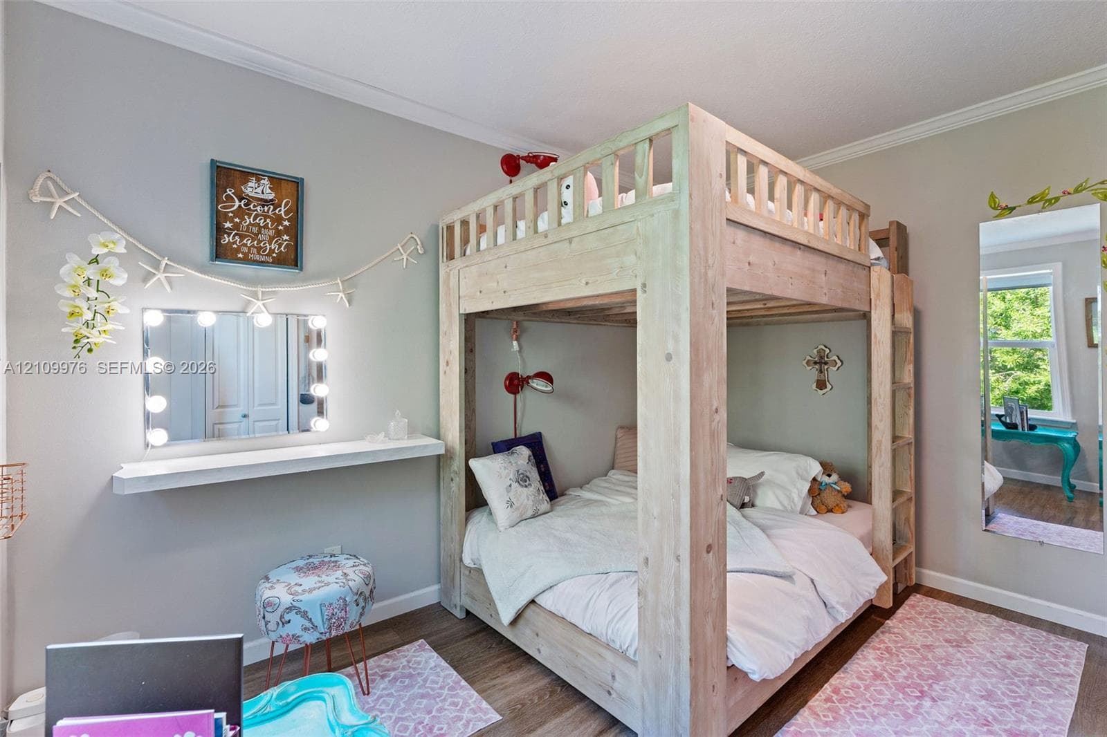 Room featuring light-toned interior paint, wood-finish flooring, and a window with natural exterior scenery