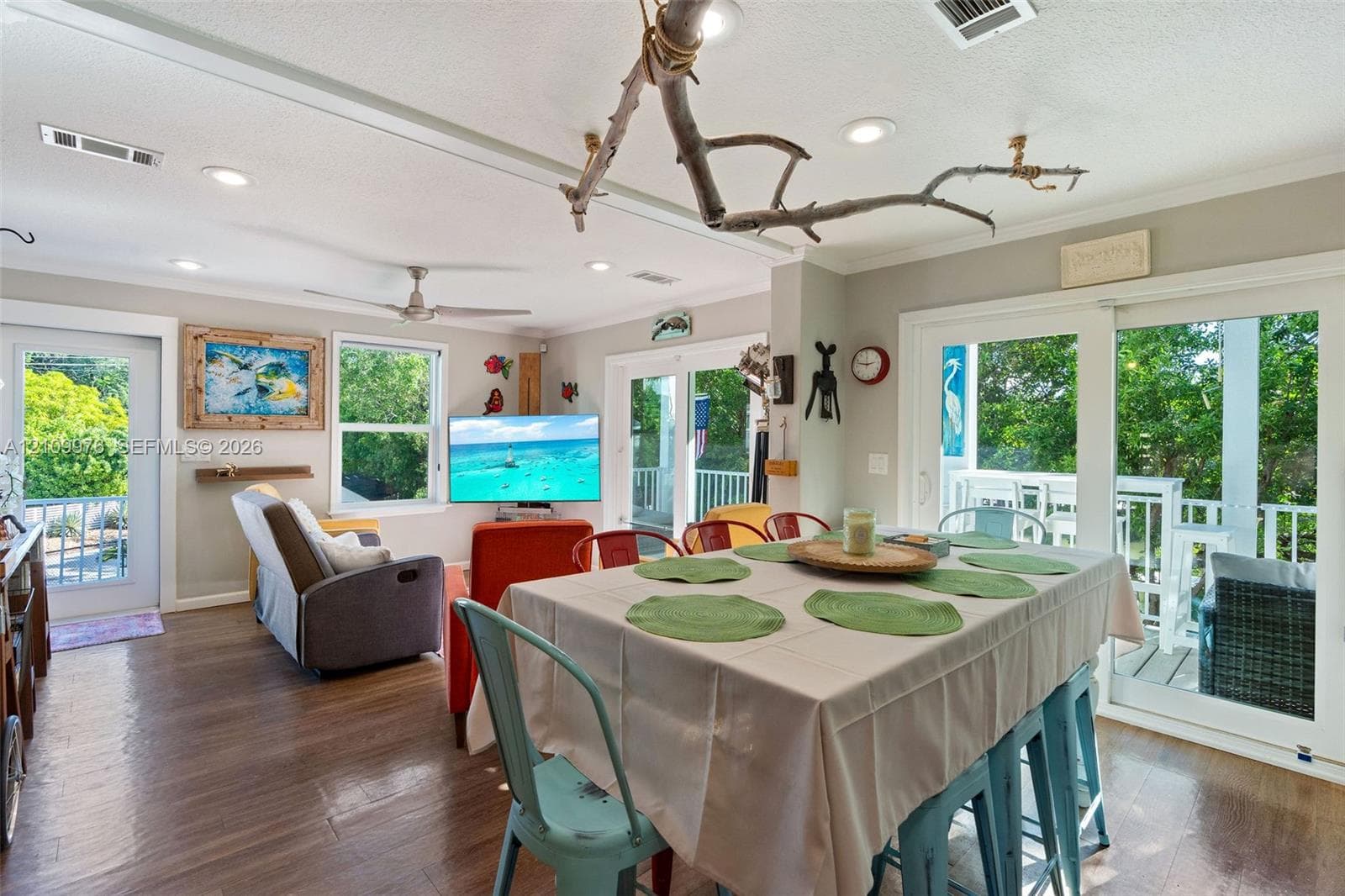Open-concept floor plan featuring wood-finish flooring, recessed lighting, ceiling fan, and sliding glass doors opening to an exterior deck
